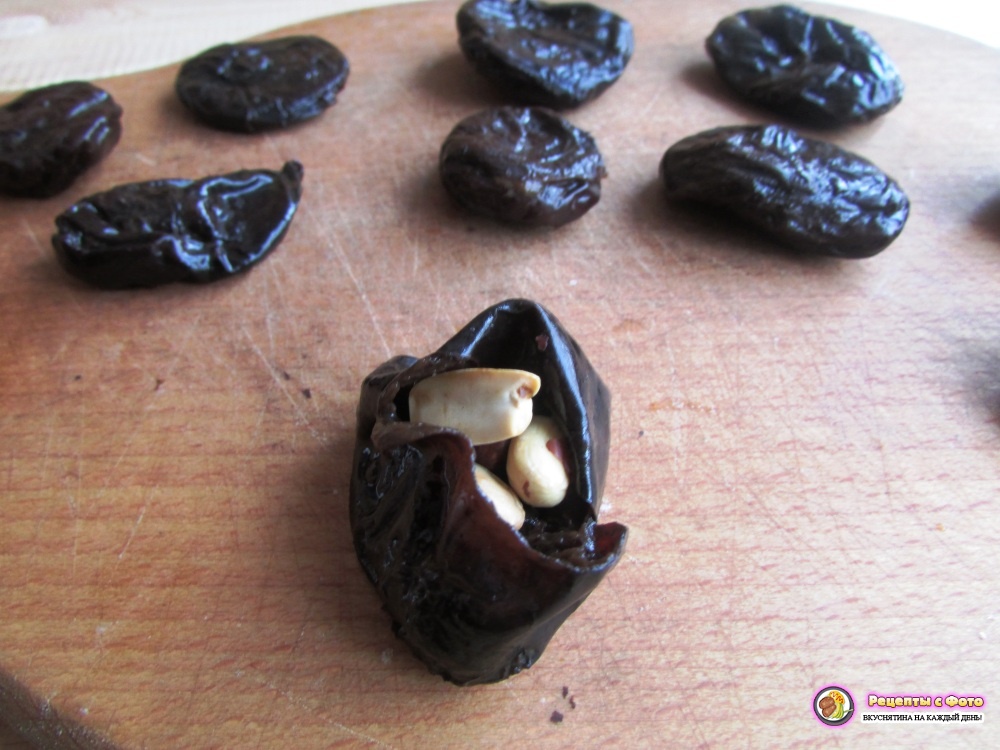 раскройте чернослив и положите внутрь его несколько жареных орешков