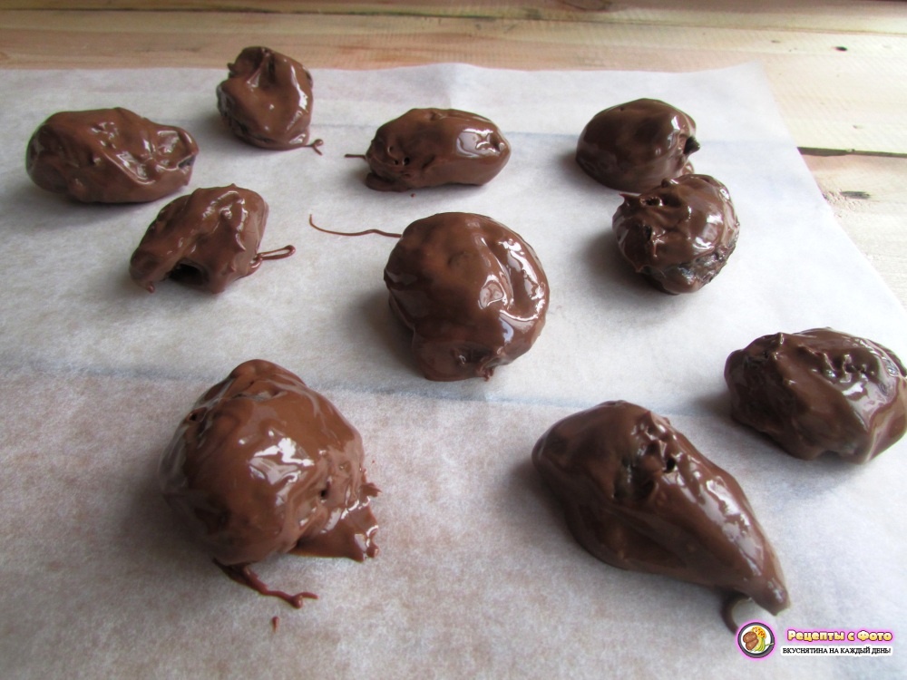 Выложите чернослив в шоколаде на пергаментную бумагу и отправьте сладости в морозильную камеру